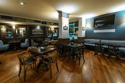 a restaurant with tables and chairs and a television on the wall at Amérian Executive Córdoba in Cordoba