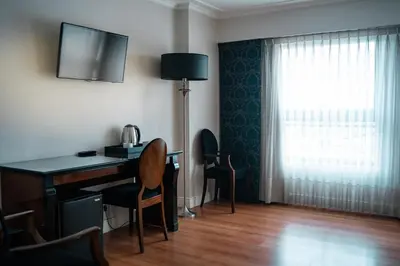 a room with a desk with a lamp and a window at Amérian Executive Córdoba in Cordoba