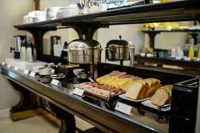 a breakfast buffet with meats and cheese and bread at Amérian Executive Córdoba in Cordoba