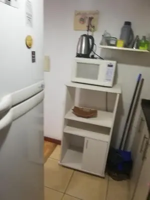 a microwave sitting on top of a white shelf in a kitchen at VICTORIA PARK in Villa Carlos Paz