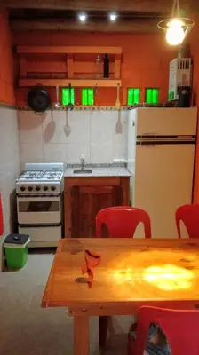 a kitchen with a table and a stove and a refrigerator at Dpto La Bicicleta solar in Villa Independencia