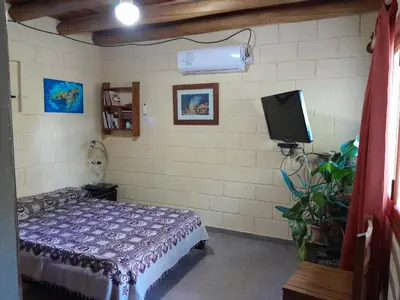 a bedroom with a bed and a tv in it at Dpto La Bicicleta solar in Villa Independencia