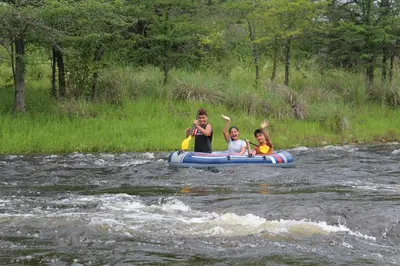 three people riding on a raft in a river at Amaneceres de San Isidro in José de la Quintana