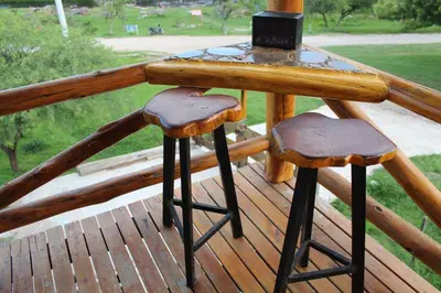 a table and two stools on a wooden deck at Amaneceres de San Isidro in José de la Quintana