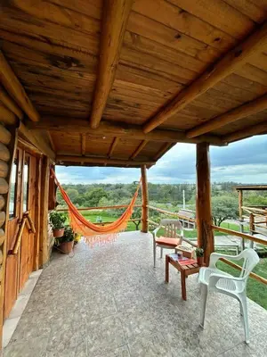 a large porch with chairs and a hammock at Amaneceres de San Isidro in José de la Quintana