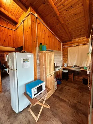 a kitchen with a refrigerator and a microwave on a stand at Amaneceres de San Isidro in José de la Quintana