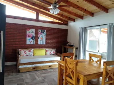 a living room with a couch and a table at Cabañas Matices del Lago in Villa Ciudad Parque