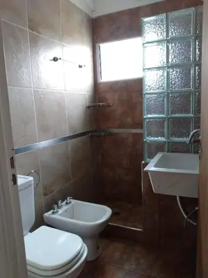 a bathroom with a toilet and a sink and a window at Cabañas Matices del Lago in Villa Ciudad Parque