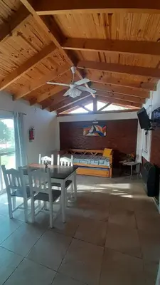 a dining room with a table and chairs and a bed at Cabañas Matices del Lago in Villa Ciudad Parque