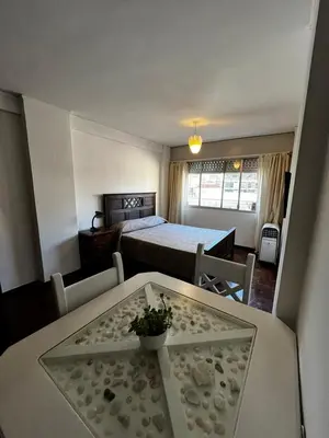 a small room with a bed and a table with a table sidx sidx sidx at Punto Quiros - Monoambiente centrico, a la vuelta del Patio Olmos in Cordoba
