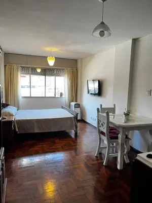 a bedroom with a bed and a desk and a table at Punto Quiros - Monoambiente centrico, a la vuelta del Patio Olmos in Cordoba