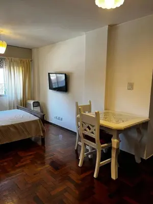 a bedroom with a table and a bed and a television at Punto Quiros - Monoambiente centrico, a la vuelta del Patio Olmos in Cordoba