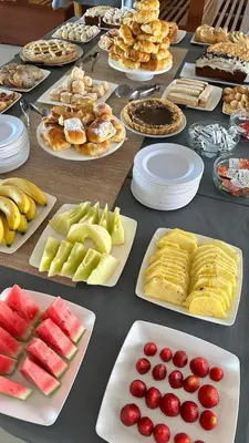 a table topped with plates of food and fruit on plates at Hotel 376 in Villa Carlos Paz