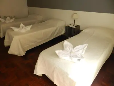 a hotel room with two beds with white flowers on them at Hotel 376 in Villa Carlos Paz