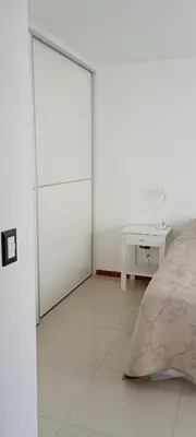 a white room with a bed and a table at Departamento centrico carlos paz in Villa Carlos Paz