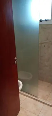 a bathroom with a toilet and a glass shower door at Departamento centrico carlos paz in Villa Carlos Paz