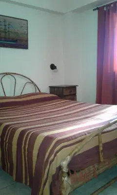 a bedroom with a bed with a striped blanket at Departamento Centro Villa Carlos Paz in Villa Carlos Paz