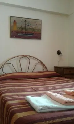 a bedroom with a bed with a painting on the wall at Departamento Centro Villa Carlos Paz in Villa Carlos Paz
