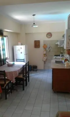 a kitchen with a table and a refrigerator at Departamento Centro Villa Carlos Paz in Villa Carlos Paz