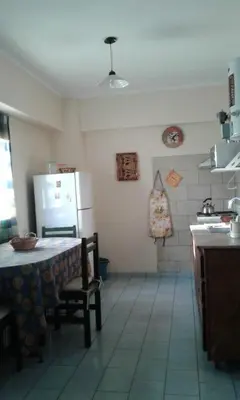a kitchen with a table and a refrigerator at Departamento Centro Villa Carlos Paz in Villa Carlos Paz