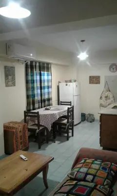 a living room with a table and a refrigerator at Departamento Centro Villa Carlos Paz in Villa Carlos Paz