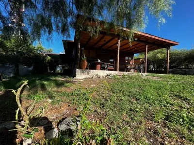 a house with a wooden pavilion in a field at el PARAISO in Villa Anizacate