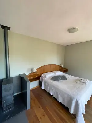 a bedroom with a bed and a wood stove at Casas Pura Vida in Villa General Belgrano