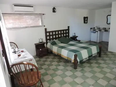 a bedroom with a bed and a table and chair at La Quebradita in San Javier