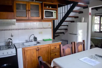 a kitchen with a sink and a white refrigerator at Cabañas Monteolivos in Merlo