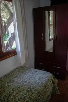 a bedroom with a bed and a dresser and a window at Cabañas Monteolivos in Merlo