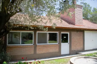 a small brick house with a white door at Cabañas Monteolivos in Merlo