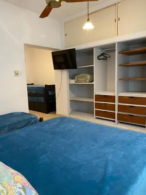 a bedroom with a bed and a tv and shelves at Departamento Hospital Privado Quality maternidad Con cochera in Cordoba