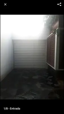 a room with a white garage door and a window at Departamento Hospital Privado Quality maternidad Con cochera in Cordoba