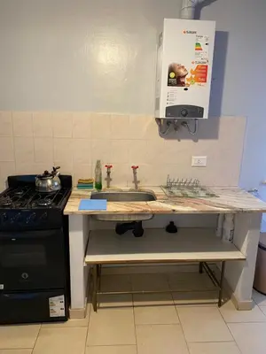 a kitchen counter with a sink and a stove at Departamento Hospital Privado Quality maternidad Con cochera in Cordoba