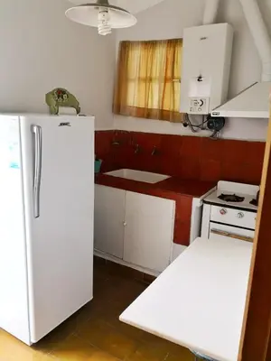 a kitchen with a white refrigerator and a stove at Casa en Villa Amancay in Amboy