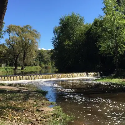 a river with a fence and trees and water at Casa en Villa Amancay in Amboy