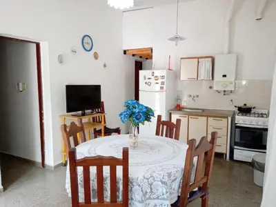 a kitchen with a table with a vase of flowers on it at Buenas Vibras in Villa Carlos Paz