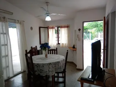 a dining room with a table with a vase of flowers on it at Buenas Vibras in Villa Carlos Paz