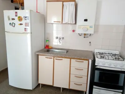 a kitchen with a white refrigerator and a sink at Buenas Vibras in Villa Carlos Paz