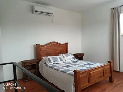 a bedroom with a bed with a blue and white blanket at Bº CERRADO LOMAS DEL REY MAYU SUMAJ in San Antonio de Arredondo