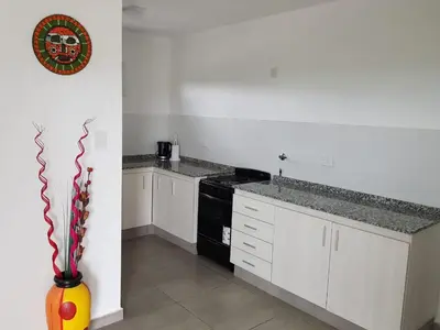 a kitchen with white cabinets and a black stove at Bº CERRADO LOMAS DEL REY MAYU SUMAJ in San Antonio de Arredondo