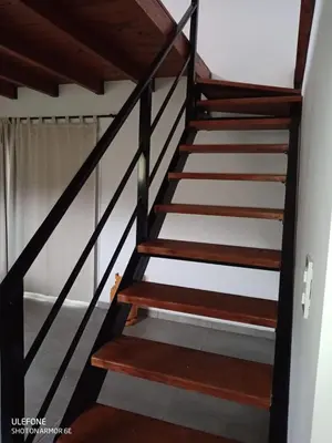 a staircase in a house with wooden railings at Bº CERRADO LOMAS DEL REY MAYU SUMAJ in San Antonio de Arredondo