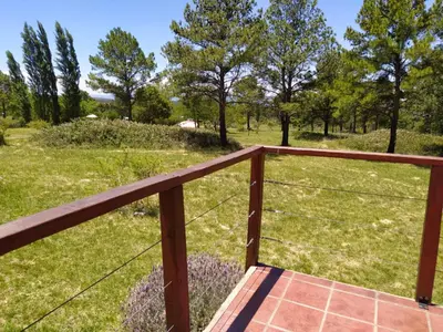 a deck with a view of a field at Mirador de Atuq - Casa Serrana in Villa Yacanto