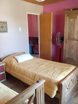 a bedroom with two beds in a room with pink walls at Mirador de Atuq - Casa Serrana in Villa Yacanto