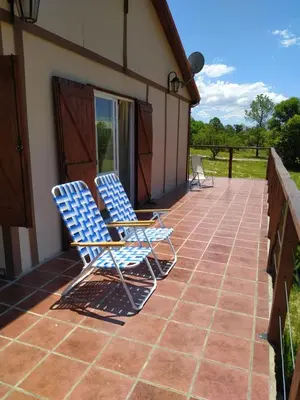 two chairs sitting on the porch of a house at Mirador de Atuq - Casa Serrana in Villa Yacanto