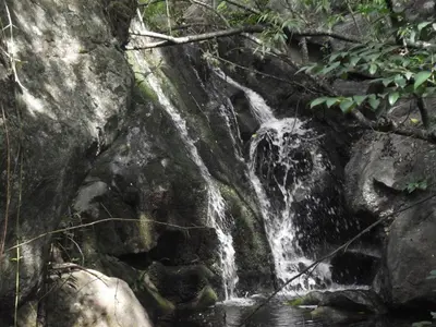 a waterfall on the side of a rock wall at Mirador de Atuq - Casa Serrana in Villa Yacanto