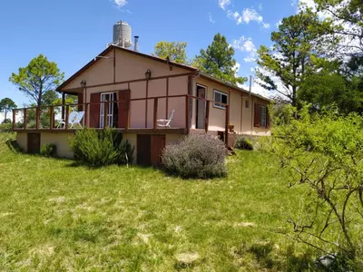 a house on top of a grassy field at Mirador de Atuq - Casa Serrana in Villa Yacanto