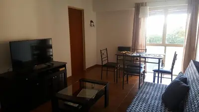 a living room with a couch and a table with chairs at Luminoso departamento en Cañada y a pasos de todo! in Cordoba