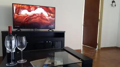 a living room with two wine glasses and a television at Luminoso departamento en Cañada y a pasos de todo! in Cordoba