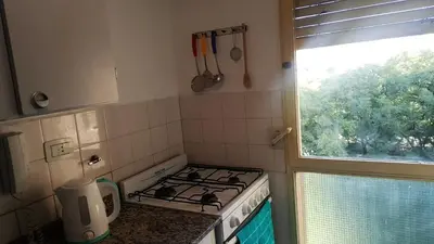 a kitchen with a stove top oven next to a window at Luminoso departamento en Cañada y a pasos de todo! in Cordoba